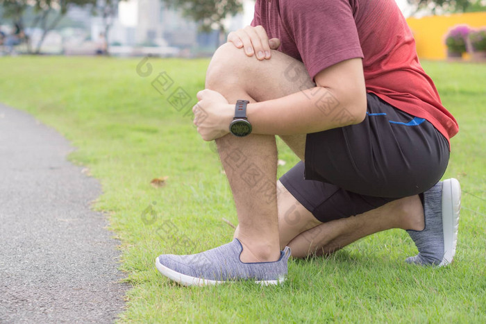 膝盖受伤年轻的体育运动男人。持有膝盖手