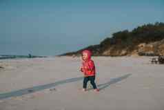 可爱的蹒跚学步的女孩阳光明媚的沙子海滩真实的生活方式童年图像