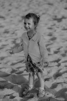 可爱的蹒跚学步的女孩阳光明媚的沙子海滩真实的生活方式童年图像