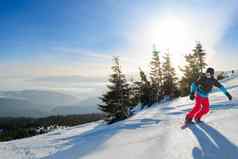 年轻的滑雪骑红色的滑雪板山阳光明媚的一天滑雪冬天体育