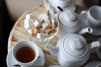 早....杯茶站边缘木桌子上广场块糖糖碗茶水壶咖啡水壶