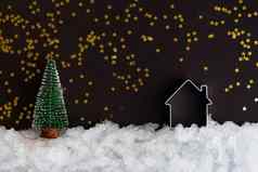 圣诞节微型房子雪黑暗背景闪亮的星星复制空间圣诞节作文明信片模板