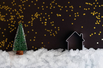 圣诞节微型房子雪黑暗背景闪亮的星星复制空间圣诞节作文明信片模板
