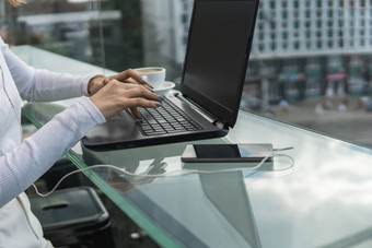 女人工作移动PC电脑表格手打字键盘女商人打字移动PC键盘坐着咖啡馆
