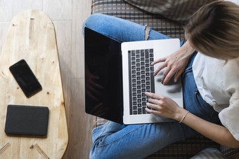 女人移动PC坐着沙发研究工作在线自由使用女人女孩工作笔记本坐着沙发上电话智能手机ereader表格