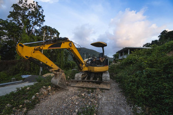 现代挖掘机建设网站日落天空大跟踪挖掘机站山绿色草机械建设建筑农村