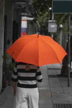 回来视图女人橙色伞走街