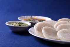 伊德利水鹿椰子酸辣酱蓝色的背景印度菜南印度最喜欢的食物拉瓦伊德利粗粒小麦粉悠闲地拉瓦悠闲地服务水鹿绿色酸辣酱