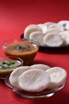 伊德利水鹿椰子酸辣酱红色的背景印度菜南印度最喜欢的食物拉瓦伊德利粗粒小麦粉悠闲地拉瓦悠闲地服务水鹿绿色酸辣酱