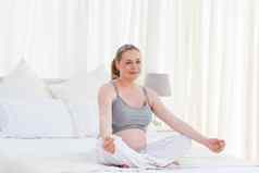 怀孕了女人练习瑜伽床上