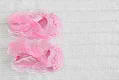 粉红色的婴儿靴白色用钩针编织毯子