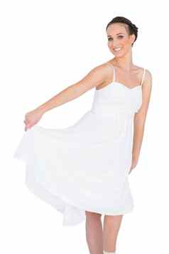 快乐的美丽的年轻的模型白色衣服跳舞