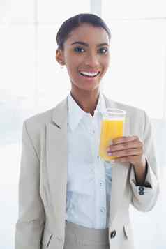 微笑优雅的女商人持有玻璃橙色汁