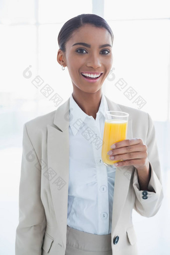 微笑优雅的女商人持有玻璃橙色汁