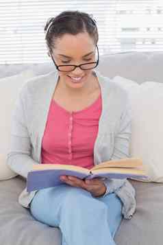聪明的女人阅读眼镜坐着沙发阅读书