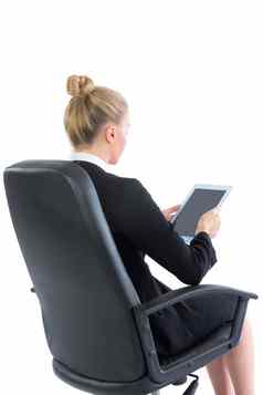 年轻的女商人坐着办公室椅子持有平板电脑
