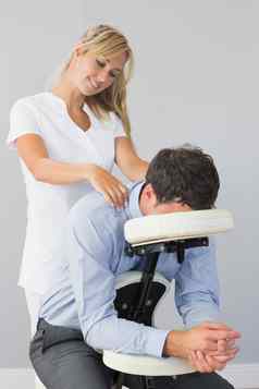 女按摩师治疗客户脖子按摩椅子