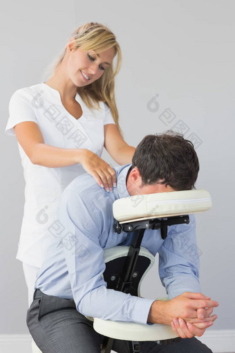 女按摩师治疗客户脖子按摩椅子