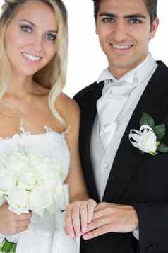 年轻的结婚了夫妇摆姿势穿婚礼环