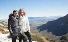 夫妇皮毛罩夹克下了雪多山的谷