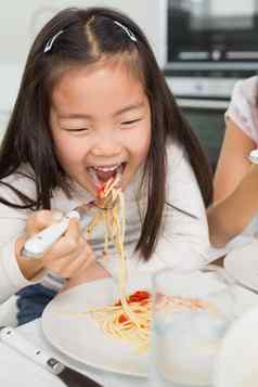 快乐年轻的孩子享受意大利面午餐厨房