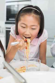 特写镜头快乐年轻的孩子享受意大利面午餐