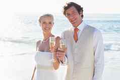 年轻的新婚夫妇敬酒香槟微笑相机
