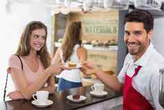 咖啡师给糕点女人计数器咖啡商店