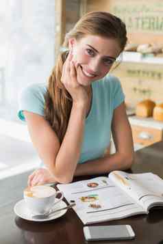 微笑女人咖啡杯阅读杂志咖啡商店