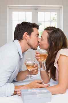 爱的年轻的夫妇接吻酒眼镜