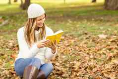 微笑漂亮的女人阅读书叶子