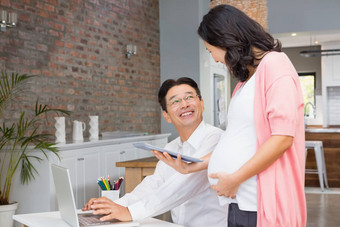 微笑怀孕了女人显示平板电脑丈夫