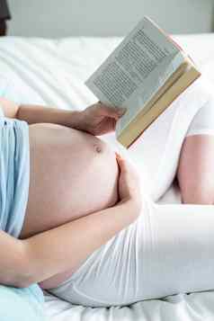 怀孕了女人床上阅读书