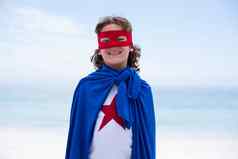 男孩穿超级英雄服装站海滩