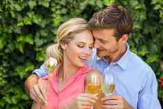 夫妇拥抱敬酒葡萄酒杯前面院子里