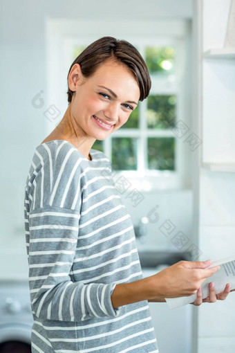 美丽的女人微笑阅读书厨房