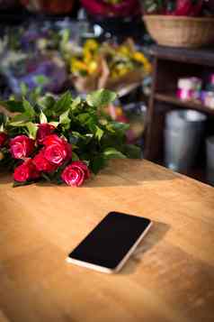 群红色的玫瑰智能手机木表格