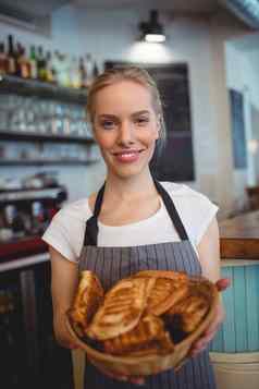 肖像快乐女服务员提供面包咖啡商店