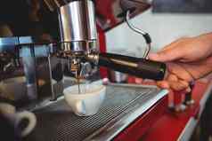 特写镜头服务员持有咖啡制造商处理咖啡馆