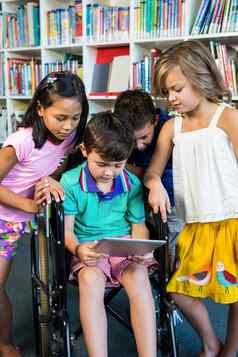 残疾男孩持有数字平板电脑朋友图书馆