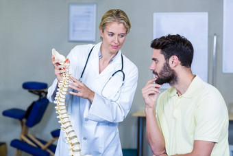 理疗师解释脊柱模型病人