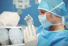 女外科医生穿外科手术面具操作剧院