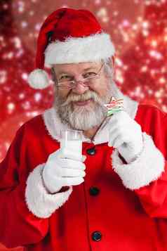 复合图像快乐的圣诞老人老人持有玻璃牛奶明星形状饼干