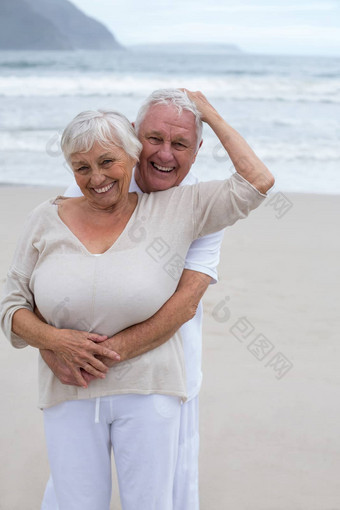高级夫妇拥抱海滩