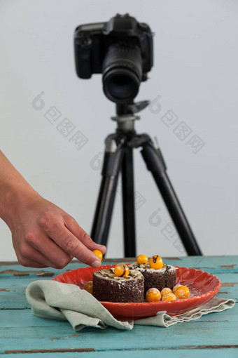 摄影师保持黄色的樱桃甜点相机背景