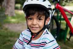 肖像微笑男孩穿自行车头盔公园