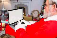 圣诞老人老人坐着移动PC
