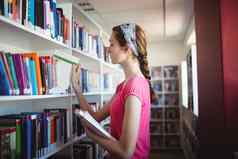女学生选择书书架子上图书馆