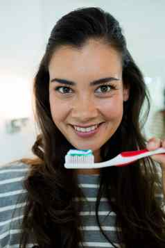 特写镜头快乐年轻的女人持有牙刷牙膏