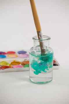 画笔蓝色的油漆下降Jar填满水